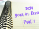 White spiral notebook on white table. Text reads '2024 Year in Review Part 1'
