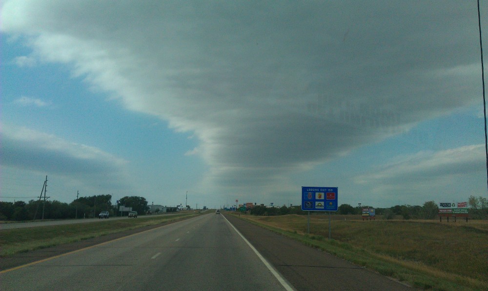 a road leading off, with a cloud overhead