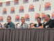 five people sitting at a table, the LA Comic Con logo on banners behind them