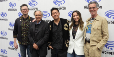 five people in front of a WonderCon banner: two white men, an Asian man, an Asian woman, and a white man
