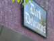 the outside of a strip mall store, #822. The top has a burgundy background and a black sign with the words 'Dark Delicacies'.